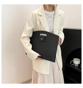 Gros plan sur la texture cuir noir et la boucle en métal du sac pour ordinateur