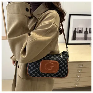 Detailed side view of vintage monogram shoulder bag with brown leather and G logo