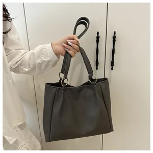 Detail of grey canvas tote bag showing twill texture and metal ring handle attachment