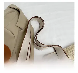 Detail of wide woven shoulder strap and beige straw bag texture with elegant piping