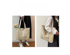 Detail view of woven straw tote bag showing both handbag and shoulder bag carrying methods