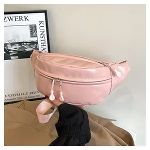 Detailed macro of pink glossy leather waist bag with double white zippers and pullers