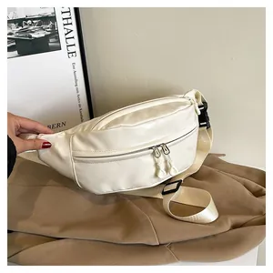 Detail of cream white faux leather waist bag showing dual zippers and woven strap
