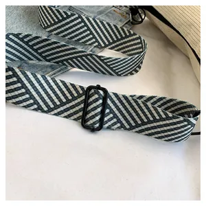 Detail of adjustable geometric striped strap with metal buckle on corduroy bag
