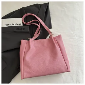 Detail of light pink woven tote bag showing fine texture and dual strap metal ring connectors