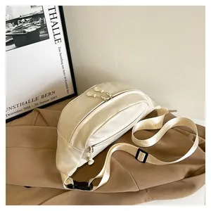 Detail of a creamy white PU leather waist bag with dual zippers and adjustable strap