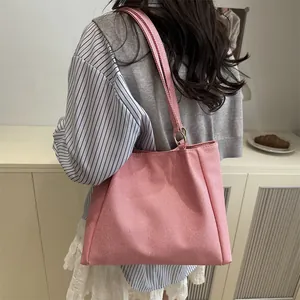 Pink canvas tote bag shown as a shoulder bag on a model for a casual spring look