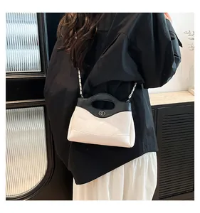 Détail du sac bandoulière matelassé avec poignées noires et logo argenté