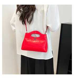 Sac à main rouge en cuir matelassé avec bandoulière chaîne porté en bandoulière