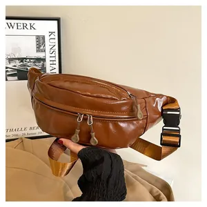 Close-up of brown glossy PU leather sports waist bag with dual zippers and adjustable strap