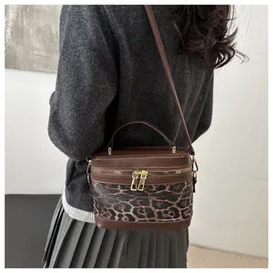 Borsa a secchiello leopardata con dettagli in pelle marrone e cerniere dorate a tracolla