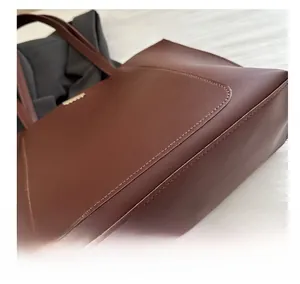 Gros plan du sac cabas en similicuir marron avec coutures soignées et grainé