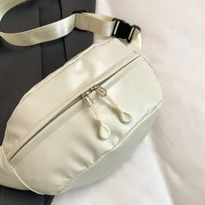 Close-up of cream PU leather waist bag with dual zippers and adjustable black buckle