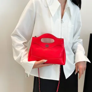 Sac à main matelassé rouge avec bandoulière chaîne et anneaux, porté par un mannequin