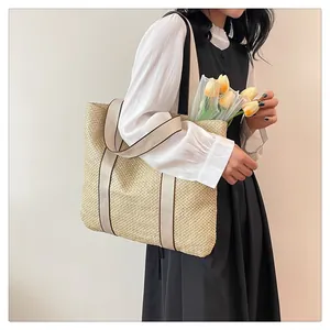 Woven straw tote bag with brown straps and tulip flowers for beach vacation style