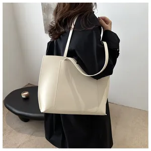 Vue détaillée du grand sac cabas en cuir PU blanc cassé montrant la texture lisse et la poche