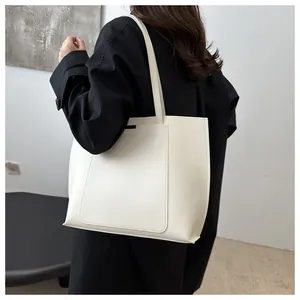 Sac fourre-tout beige minimaliste porté par un mannequin montrant sa grande capacité en PU