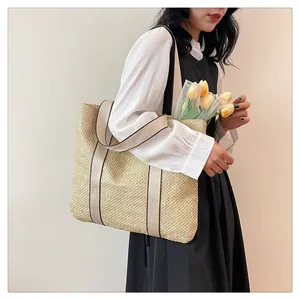 Straw tote bag with canvas straps shown on shoulder for a summer vacation look