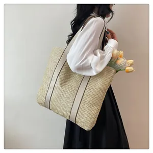 Side view of large straw tote bag with fabric handles and decorative tulips