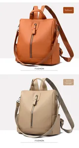 Detail view of khaki and orange-brown oxford fabric backpacks with vertical zippers
