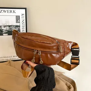 Close-up of brown oiled PU leather crossbody bag with dual zippers and nylon strap