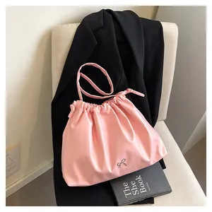Detailed view of pink pleated tote bag with silver bow accent and drawstring closure
