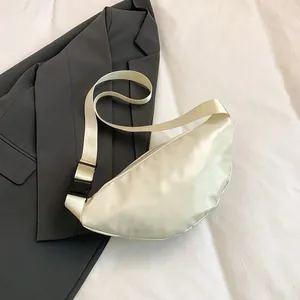Detail of cream white crescent moon waist bag showing premium faux leather texture and strap