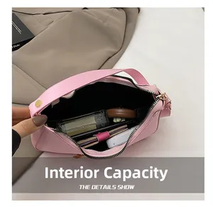 Capacité interne du sac croissant en cuir rose montrant parfum, portefeuille et maquillage