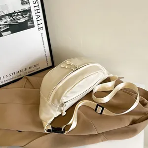 Detail view of cream sports fanny pack with dual zippers and adjustable webbing strap