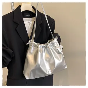 Close-up of silver pleated tote bag with bow detail and sleek metallic finish