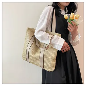 Close-up of a large capacity straw tote bag with elegant cream canvas handles for beach trips