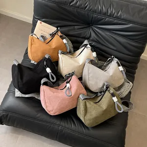 Corduroy hobo bag in six colors with striped strap shown on a vintage leather sofa