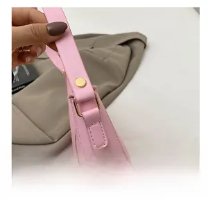 Détail du sac en cuir rose avec boucle en métal doré et rivet sur la bandoulière