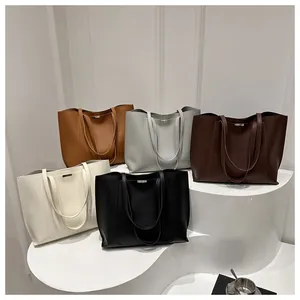 Collection de grands sacs cabas en cuir en cinq couleurs sur un socle blanc épuré