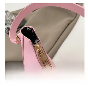 Gros plan sur la fermeture éclair dorée d'un sac sous les bras en cuir rose tendre