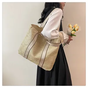 Detail view of large straw tote bag featuring woven texture and durable canvas straps