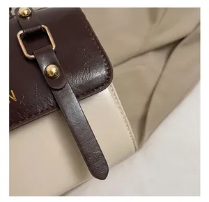 Close-up of premium gold buckle and rivet detail on a vintage leather crossbody bag