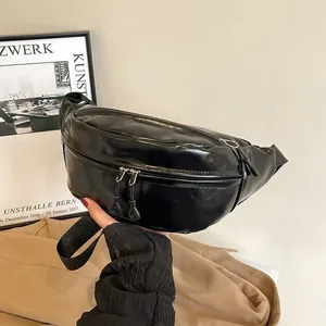 Detail of minimalist black shiny PU leather waist bag with double zipper and nylon strap