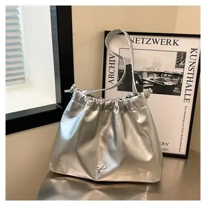Close-up of silver pleated tote bag with drawstring closure and metal bow detail