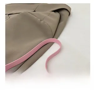 Détail en gros plan de la bandoulière rose réglable sur un sac demi-lune kaki