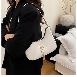 Détail d'un sac hobo en cuir blanc avec logo SS doré et pendentif à franges élégant