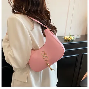 Vue détaillée d'un sac demi-lune rose avec logo doré et finitions raffinées à franges