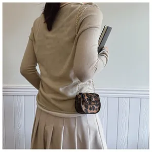 Mini-Umhängetasche mit Leopardenmuster und goldener Kette an einem Model getragen