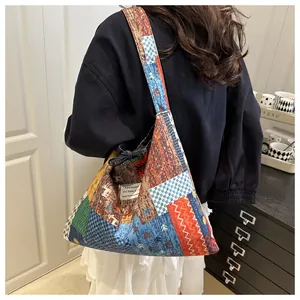 Detail der bunten Patchwork-Stofftasche mit Blumenmuster und gewebtem Fashion-Etikett