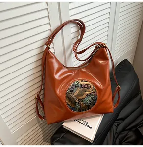 Detailed view of vintage brown leather bag with ethnic elephant embroidery and zipper