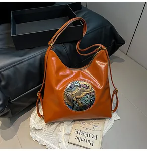 Close-up of orange-brown leather tote featuring vintage colorful elephant relief detail