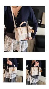 Detail of cream faux leather handbag with silk scarf, baseball charm and gold lettering