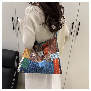Rückansicht einer großen Vintage-Patchwork-Stofftasche, getragen von einem Modell vor Weiß