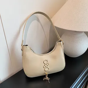 Sac hobo beige minimaliste avec pampille en métal doré et similicuir lisse élégant