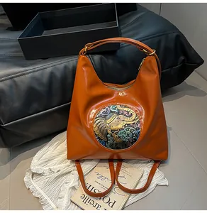 Detailed view of caramel faux leather bag with vintage floral elephant embossing